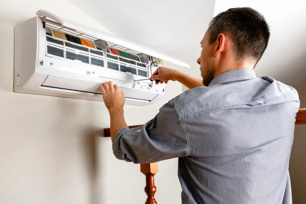 AC maintenance schedule in UAE with technician servicing a split air conditioner